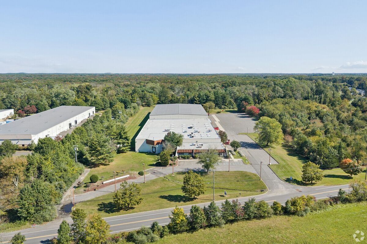 Aerial — the building, truck court and wooded site